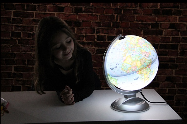 child looking at an illuminated world globe