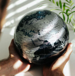 Large MOVA solar power black world globe held in hands