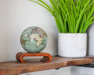 MOVA solar powered green world globe placed on shelf