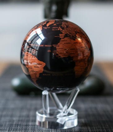 Copper Black MOVA solar power revolving world globe on table