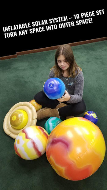 Girls sitting with inflatable solar system globes
